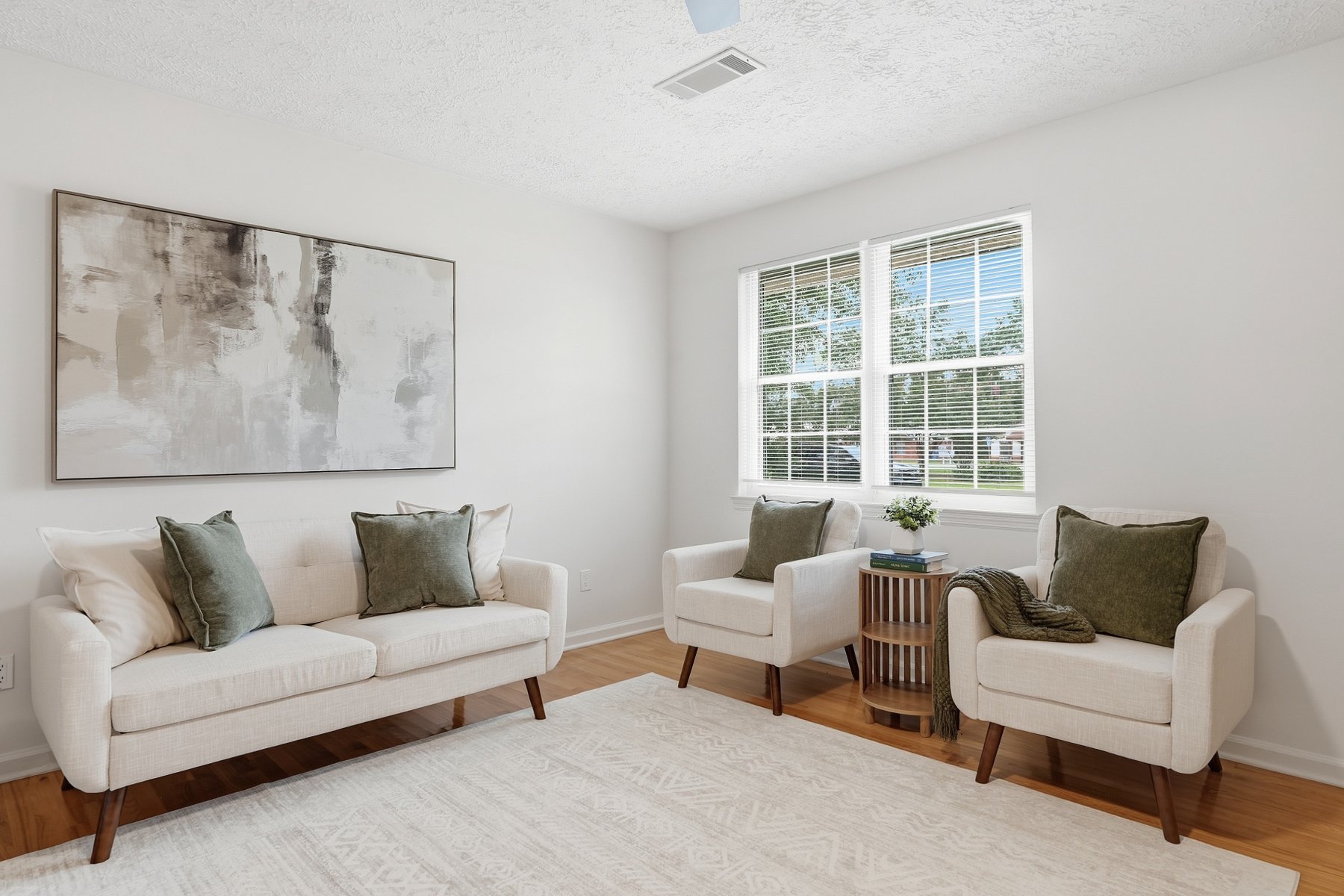 Sitting area with cream chairs and abstract art