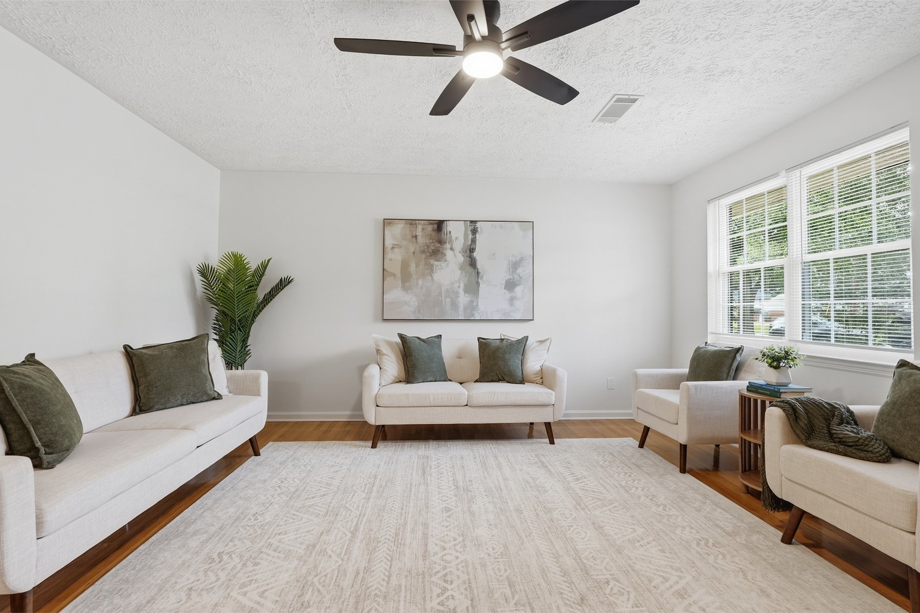 Bright living room with cream sofas and green pillows